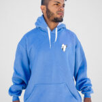 Buzo canguro oversize celeste con estampa minimalista de fantasma posando